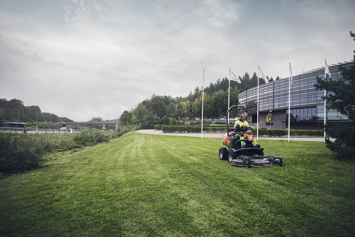 Tractor Husqvarna P525DX cu cabină, în acțiune pe peluză
